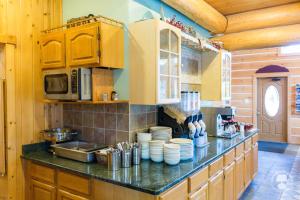 a kitchen with a counter with plates and a microwave at Cabin Creek Inn in Thayne