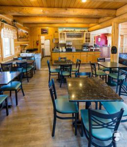 a restaurant with tables and chairs and a kitchen at Cabin Creek Inn in Thayne