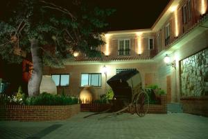uma carruagem puxada a cavalo em frente a uma casa à noite em Gran Hostal El Chiscón em Colmenar Viejo