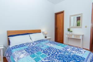 a bedroom with a bed with a blue and white quilt at Torralta Apartment in Alvor