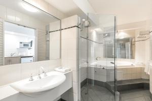 a white bathroom with a sink and a shower at Great Eastern Motor Lodge in Perth +11 photos
