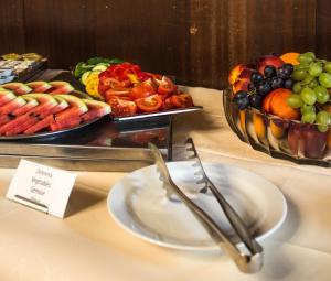 una mesa con un plato de comida y un bol de fruta en Hotel Continental en Plzeň