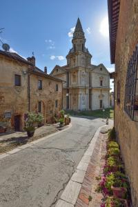 un vieux bâtiment en pierre avec une tour dans une rue dans l'établissement Alberto Charming Home, à Montepulciano