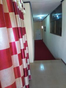 a hallway with a red and white curtain in a room at Nass Lodge in Sunyani