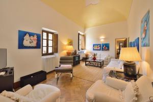 a living room with white couches and chairs at Alberto Charming Home in Montepulciano