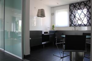 uma cozinha com armários pretos e uma mesa e cadeiras em MOZART42 em Fellbach