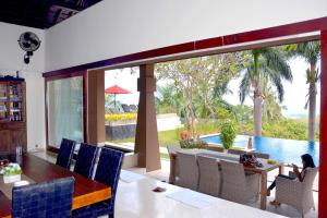 a dining room with a table and a view of a pool at Villa Tiara in Senggigi