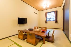 ein Esszimmer mit einem Holztisch und Stühlen in der Unterkunft JAPANING Senkyu in Kyoto