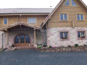 a log home with a wooden door and windows at Chambres d'hôtes la Ferme du Canard Argenté in Provenchères-sur-Fave