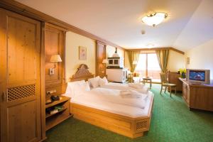 ein Hotelzimmer mit einem großen Bett in einem Zimmer in der Unterkunft Alpenromantik-Hotel Wirlerhof in Galtür