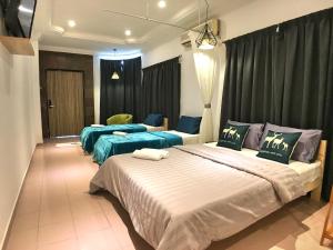 Habitación de hotel con 2 camas con sábanas azules en iBook Gurney Suites, en George Town