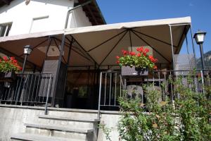 un edificio con una tienda de campaña con flores en las escaleras en Ristorante Groven, en Lostallo