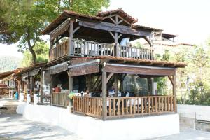 a building with a restaurant with a balcony at Haus Platanos Apartments & Bungalows by the Sea in Vourvourou