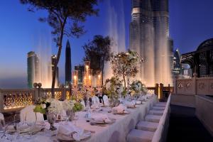 a long table with flowers on it with a city skyline at Palace Downtown in Dubai