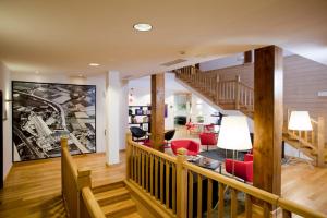 a living room with a staircase and red chairs at Hotel Dolarea in Beasain