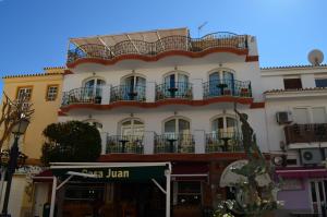 a tall white building with balconies on a street at Plazamar in Torremolinos