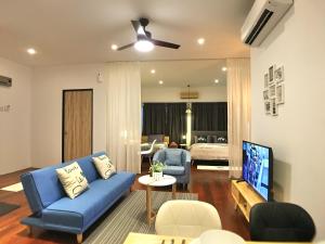ジョージタウンにあるiBook Gurney Suitesのリビングルーム(青いソファ、テレビ付)
