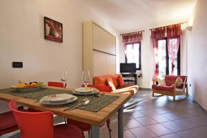 un soggiorno con tavolo da pranzo e sedie rosse di Bilocale Pieggio a Oggebbio