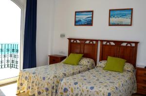 a bedroom with two beds with green pillows at Plazamar in Torremolinos