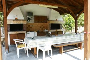 a kitchen with a large table and chairs in a pavilion at Haus Platanos Apartments & Bungalows by the Sea in Vourvourou