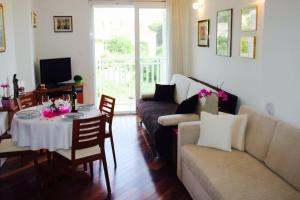 una sala de estar con un sofá y una mesa en Apartment Maria - free garage, en Dubrovnik