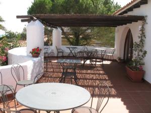 an outdoor patio with tables and chairs and a pergola at Hotel Villa Mediterranea in Noto Marina