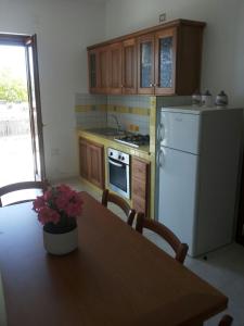 卡梅羅塔濱海的住宿－Appartamenti La Chiandata，厨房配有桌子和白色冰箱。