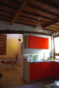 uma cozinha com armários vermelhos e uma sala de jantar em Charming apartment em Siena