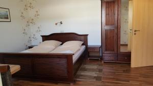 a bedroom with a wooden bed with white pillows at Pension Weiß in Zinnowitz