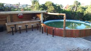 a hot tub with a table and stools around it at Dolphin View Guesthouse in Jeffreys Bay