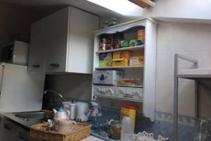 a kitchen with a sink and a shelf with food at Alma de Roma in Rome