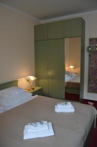 a bedroom with two towels on a bed with a mirror at HOTEL ARÉNA in Prague
