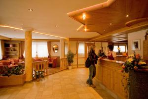 eine Frau steht an einem Tresen in einer Hotellobby in der Unterkunft Schmalzlhof Hotel & Apartments in Oberrasen + 51 Fotos