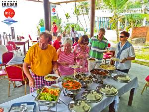 grupa ludzi stojących przy stole z jedzeniem w obiekcie Latheena Resort w mieście Weligama