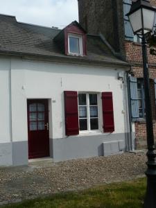Casa blanca con puertas rojas y luz de la calle en Escale Baie de Somme, en Saint-Valery-sur-Somme