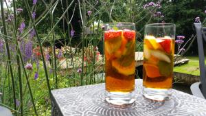 two glasses of fruit on a table in a garden at Weir Cottage in Fordingbridge