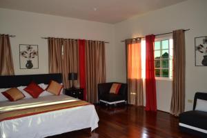 1 dormitorio con 1 cama, 1 silla y 1 ventana en Negril Sky Blue Resorts LTD, en Negril