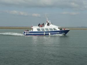 een blauwe en witte boot op het water bij Escale Baie de Somme in Saint-Valery-sur-Somme