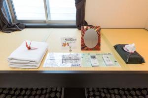 einen Tisch mit einem Spiegel und Handtüchern darauf in der Unterkunft Fujitaya BnB in Kyoto