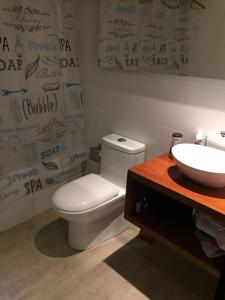 a bathroom with a white toilet and a sink at Cabañas Rincon de Pupuya in Matanzas