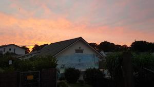 a house with a sunset in the background at Pension Weiß in Zinnowitz