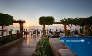 un complexe avec une piscine offrant une vue sur l'océan dans l'établissement Hotel Rocca Della Sena, à Tropea