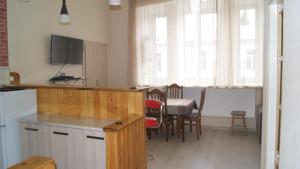 eine Küche und ein Esszimmer mit einem Tisch und einem TV in der Unterkunft Modern Apartment Avlabari in Tbilisi City