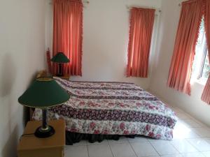 a bedroom with a bed and a green lamp at Admiral Villa in Carita