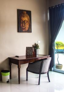 a wooden table with a chair and a picture of a head at The Miracle Guesthouse & Diving in Ko Tao