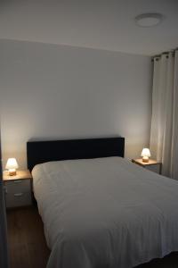 Un dormitorio con una cama blanca y dos mesitas de noche. en A vous les Trois Vallées, en Brides-les-Bains