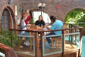 um grupo de pessoas sentadas em torno de uma mesa em um pátio em Dolphin View Guesthouse em Jeffreys Bay