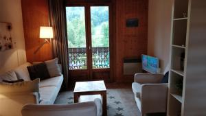 a living room with a couch and chairs and a television at Between lake en ski resort in Thollon
