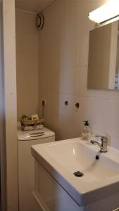 a white bathroom with a sink and a mirror at Between lake en ski resort in Thollon