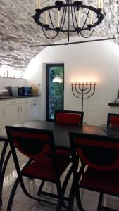 a dining room table with red chairs and a chandelier at Fienile in Avegno